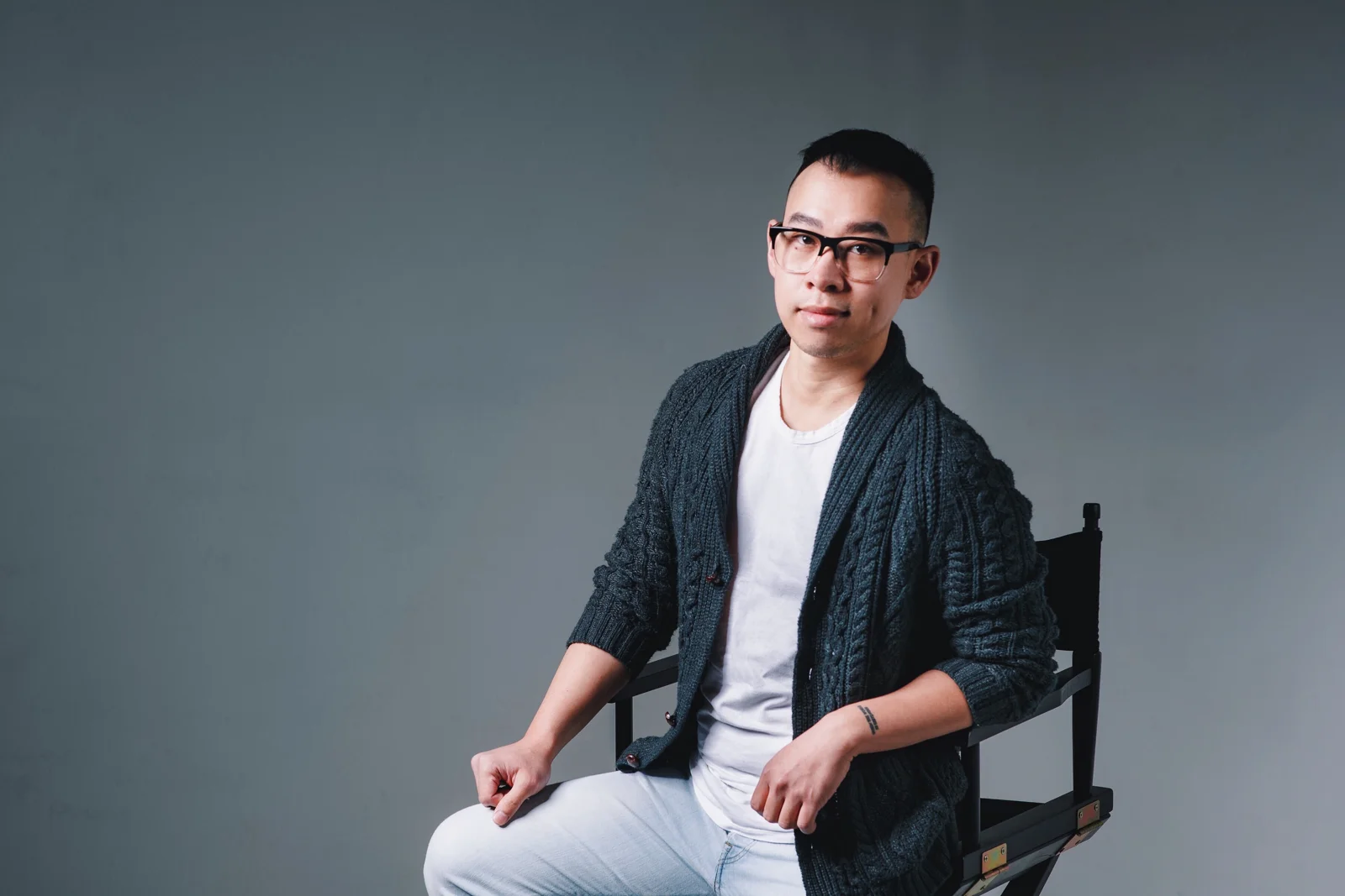 Kane Diep seated in a director’s chair