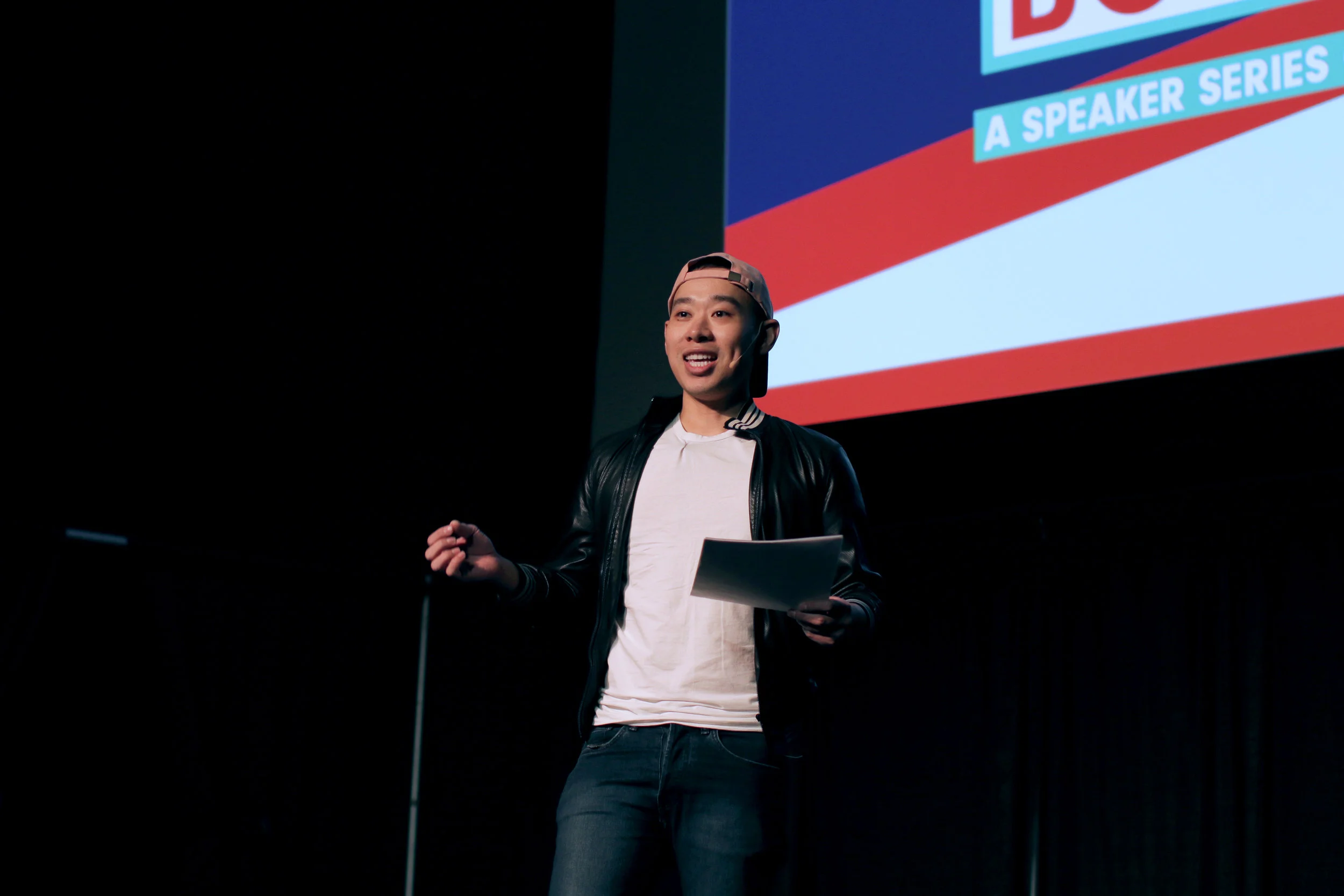 Kane speaking on stage at Boston University